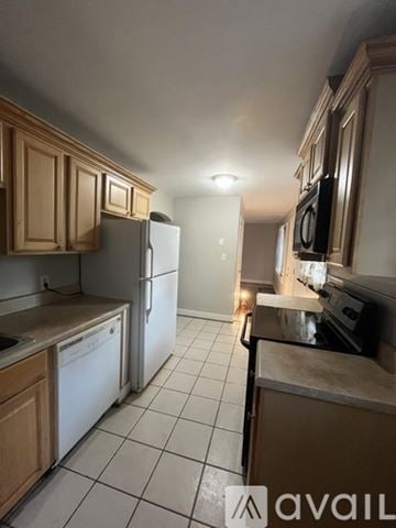 Petersburg house for rent - A kitchen with wooden cabinets and a white refrigerator.