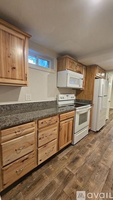 Murray house for rent - A kitchen with wooden cabinets and a granite countertop.