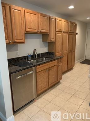 Old Orchard Beach townhouse for rent - A kitchen with wooden cabinets and a stainless steel dishwasher.
