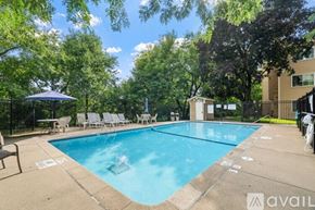 Minneapolis condo for rent - A pool surrounded by trees and chairs.