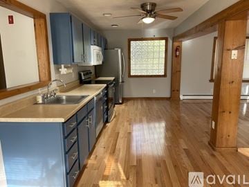 Easton house for rent - A kitchen with blue cabinets and a wooden floor.