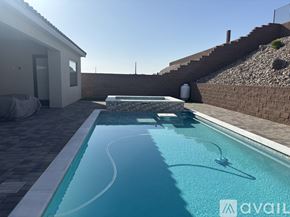 Lake Havasu City house for rent - A small residential pool with a white wall and a stone staircase.