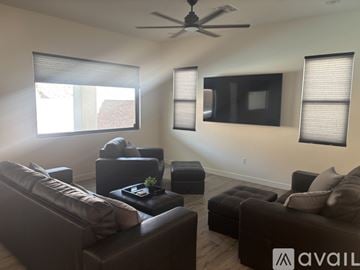 Lake Havasu City house for rent - A living room with a brown leather couch and a ceiling fan.