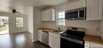 Alcoa house for rent - A kitchen with white cabinets and a black stove top oven.