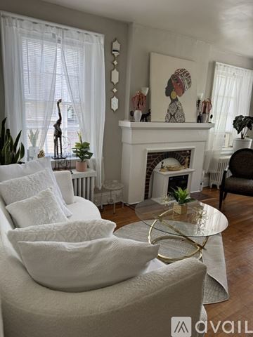 Petersburg apartment for rent - A living room with a white couch and a fireplace.