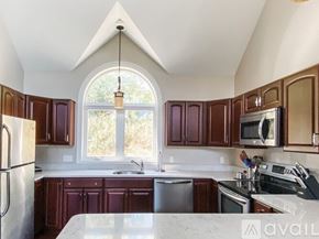 Thornton house for rent - A kitchen with brown cabinets and a white counter top.