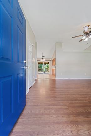 Jacksonville house for rent - A long hallway with blue doors and wood floors.