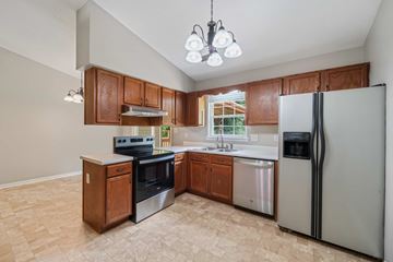 Jacksonville house for rent - A kitchen with a refrigerator, stove, and oven.