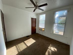 Louisville apartment for rent - A room with a ceiling fan and a window with blinds.