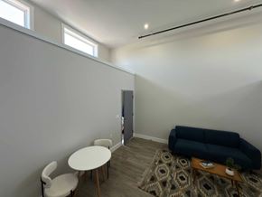 Pictou apartment for rent - A living room with a blue couch, a white chair, and a small table.