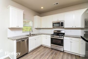 Dallas house for rent - A kitchen with white cabinets and stainless steel appliances.