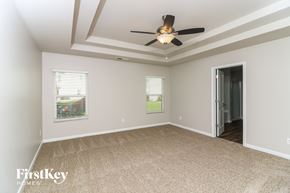 Dallas house for rent - A spacious room with a ceiling fan and carpeted floor.