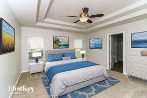 Dallas house for rent - A bedroom with a bed, dresser, and ceiling fan.