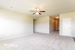 Montevallo house for rent - A spacious room with a carpeted floor and a ceiling fan.