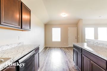 Montevallo house for rent - A kitchen with dark brown cabinets and marble countertops.