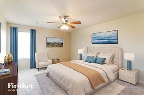 Montevallo house for rent - A bedroom with a large bed, a ceiling fan, and a painting on the wall.