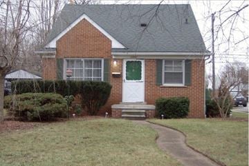 Redford Charter Township house for rent - A brick house with a white door and green shutters.