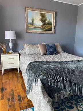 Trinidad apartment for rent - A bedroom with a bed, a nightstand, and a painting on the wall.