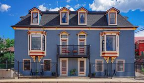 Trinidad apartment for rent - A two-story house with a balcony and a black fence.