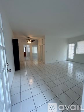 Surfside apartment for rent - A white house with a red tile roof and a sign that says "available" in front of it.