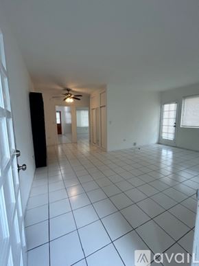 Surfside apartment for rent - A room with white walls, a tiled floor, and a window with blinds.