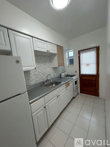 Surfside apartment for rent - A white kitchen with a stove and sink.
