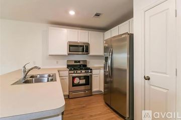 New Caney house for rent - A kitchen with a stainless steel refrigerator, microwave, oven, and sink.