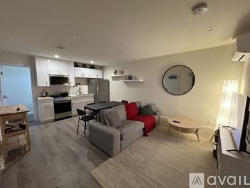 San Diego house for rent - A living room with a grey couch and a round mirror on the wall.