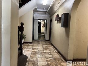 Los Angeles apartment for rent - A long hallway with a plant on the left and a door at the end.