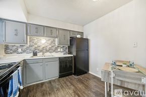 San Antonio apartment for rent - A kitchen with a black refrigerator and wooden floors.