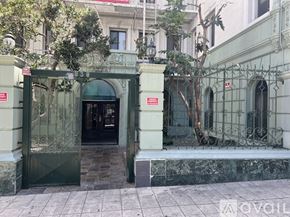 Los Angeles apartment for rent - A green and white building with a black door and a red sign on the wall.