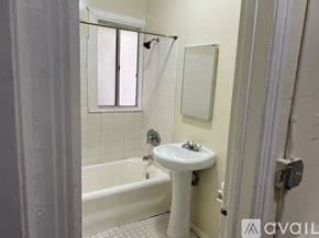 Los Angeles apartment for rent - A bathroom with a white tub, sink, and tiled walls.