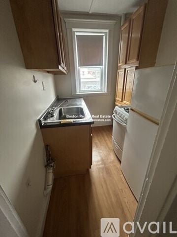 Boston apartment for rent - A kitchen with wooden cabinets and a white fridge.
