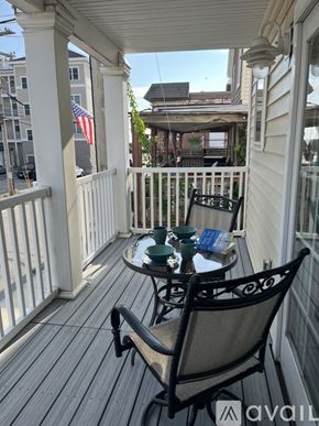 Hampton condo for rent - A patio with a table and chairs and an American flag.