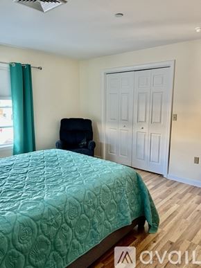 Hampton condo for rent - A bedroom with a bed, chair, and a door.