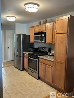 Hampton condo for rent - A kitchen with wooden cabinets and black appliances.