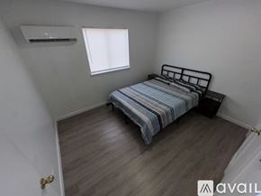 Fort Stockton apartment for rent - A bedroom with a bed, wooden flooring, and a window with blinds.