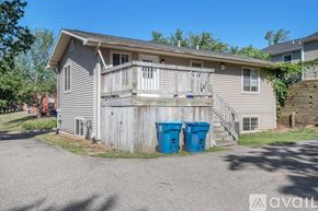 Kalamazoo house for rent - A house with a grey siding and a wooden fence.