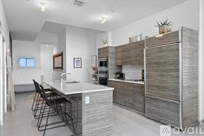 Miami apartment for rent - A modern kitchen with a white countertop and a sink.