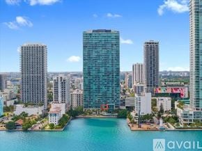 Miami apartment for rent - A cityscape with a body of water in the foreground and buildings of varying heights.