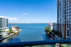 Miami apartment for rent - A view from a balcony overlooking a body of water with buildings on either side.