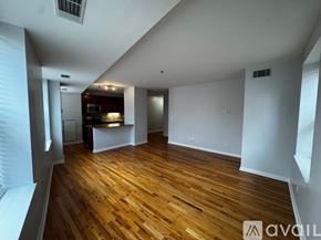 Chicago apartment for rent - A room with wooden floors and white walls, with a bar area in the corner.