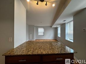 Chicago apartment for rent - A spacious room with a granite countertop and a window with blinds.