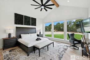 Gainesville house for rent - A bedroom with a large bed and a ceiling fan.
