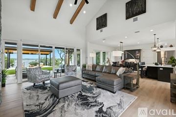 Gainesville house for rent - A modern living room with a large grey rug and a grey ottoman.
