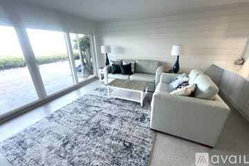 Longboat Key condo for rent - A living room with a white couch and a grey rug.