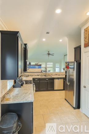Montgomery County house for rent - A kitchen with black cabinets and a marble countertop.