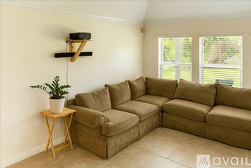 Montgomery County house for rent - A living room with a brown couch and a small table with a plant on it.