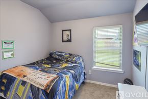 Montgomery County house for rent - A bedroom with a bed covered in a blue and yellow comforter.