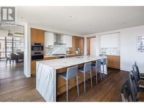 Vancouver apartment for rent - A modern kitchen with a marble island and wooden floors.
